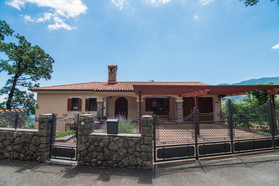 Widok z przodu willi z wejściem i bramą