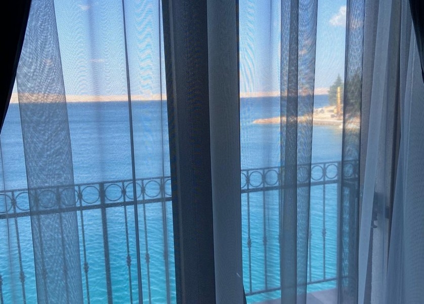 Widok na morze przez zasłonę w sypialni