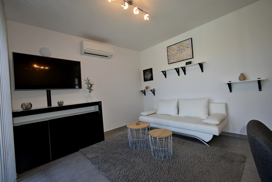 Pokój dzienny z sofą, telewizorem i klimatyzacją