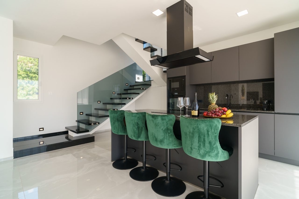 Nowoczesna kuchnia z wyspą i stołkami barowymi