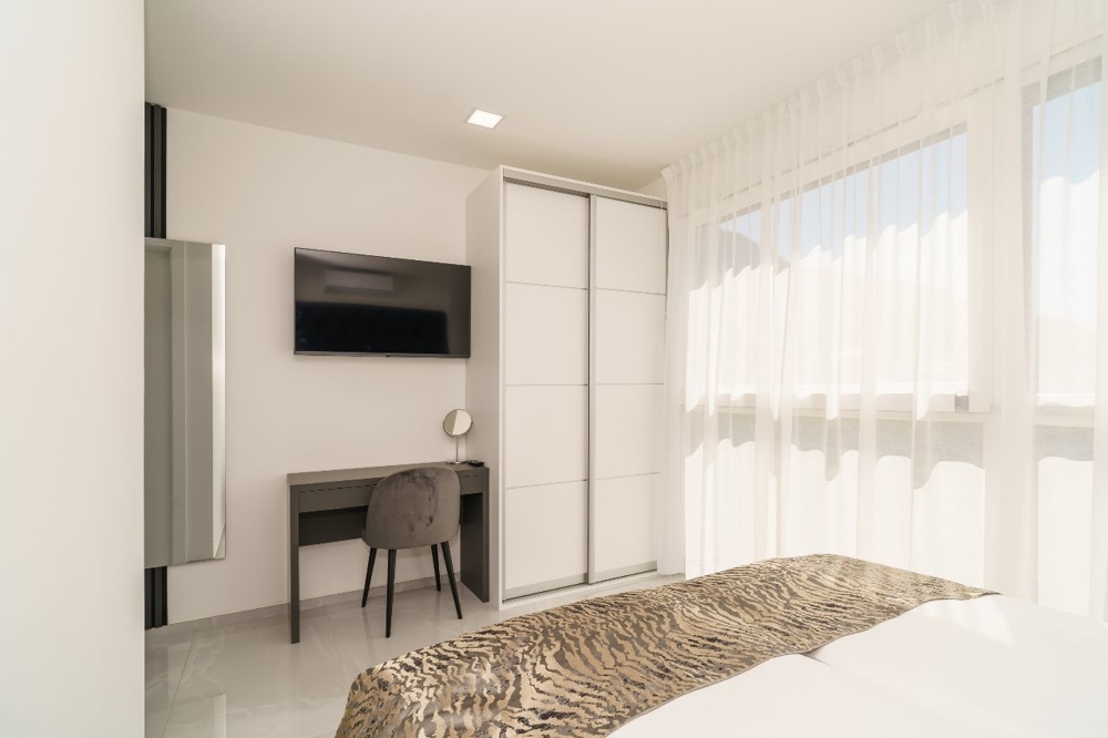 Jasna sypialnia z biurkiem i telewizorem