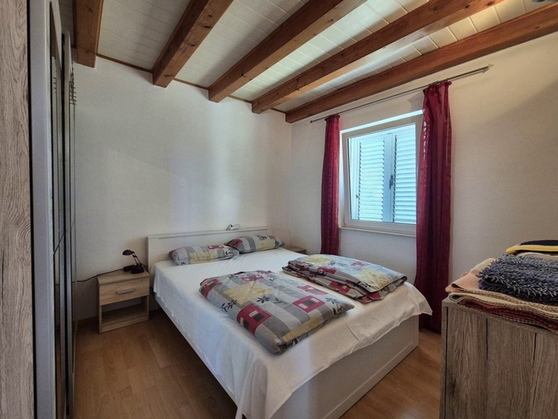 Sypialnia z podwójnym łóżkiem i belkami stropowymi