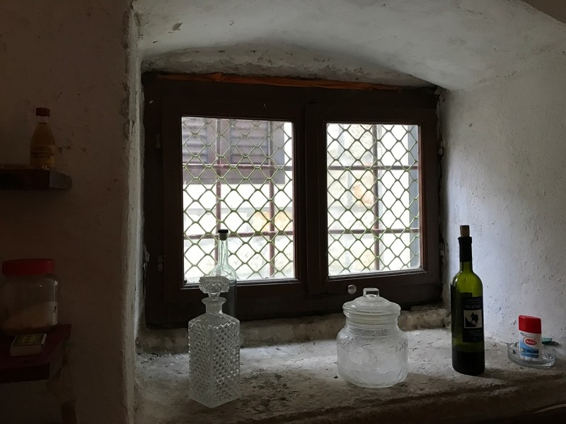 Okno z kratami i szklanymi butelkami