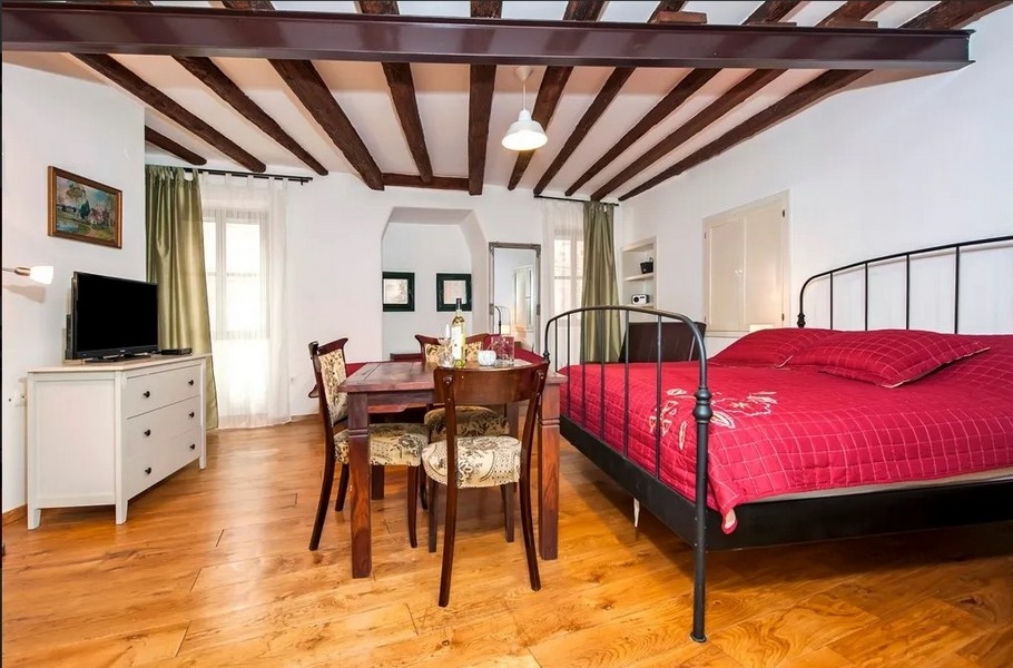 Jasny apartament z łóżkiem, drewnianymi belkami i stołem