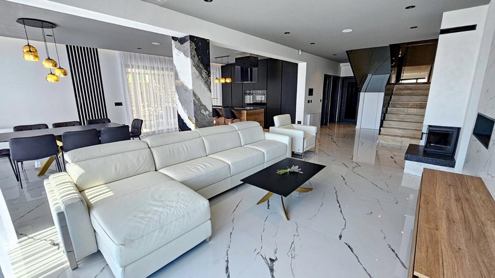 Część dzienna z jasną kanapą i kominkiem