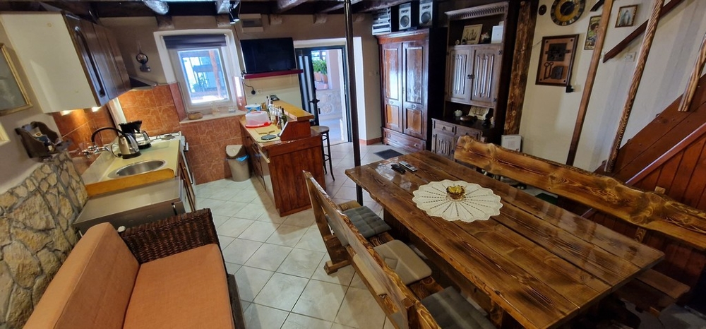 Kuchnia-salon z drewnianymi meblami i aneksem kuchennym