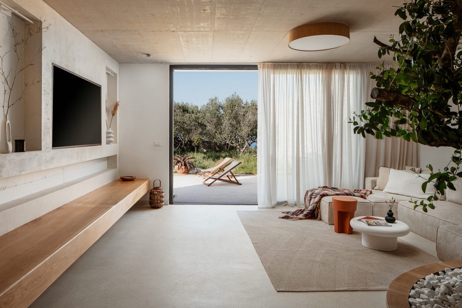 Pokój dzienny z oknami sięgającymi od podłogi do sufitu i dostępem do ogrodu