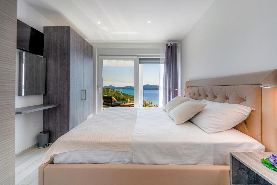 Sypialnia z podwójnym łóżkiem, szafą i widokiem na morze