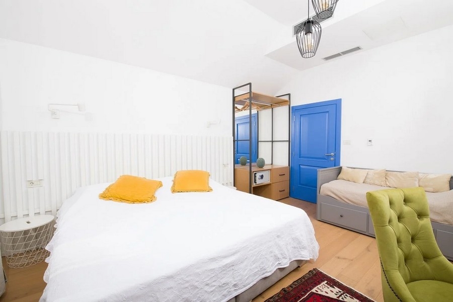 Sypialnia z podwójnym łóżkiem, niebieskimi drzwiami i szafą