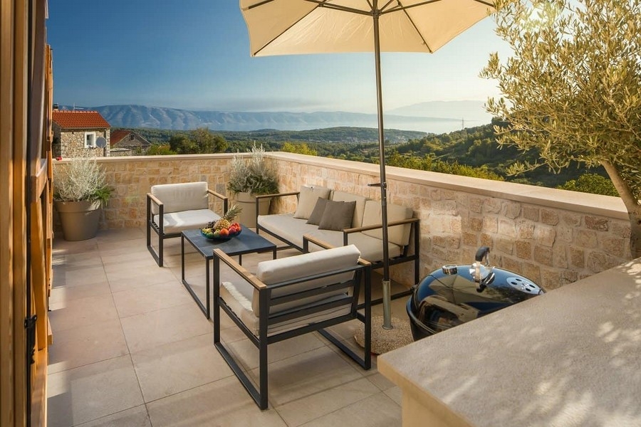 Taras z miejscem do siedzenia, parasolem i widokiem na morze