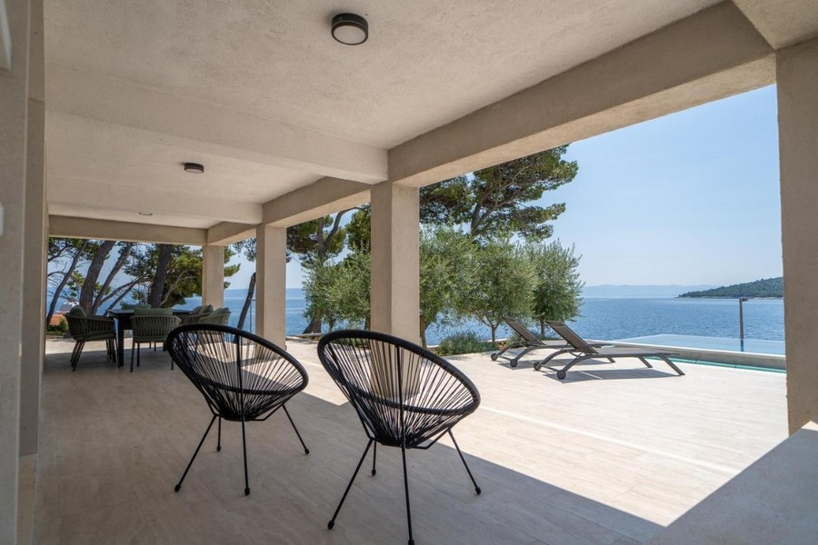 Zadaszony taras z częścią wypoczynkową i widokiem na morze