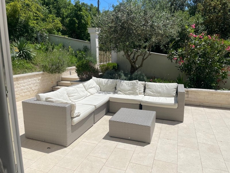 Taras ogrodowy z częścią wypoczynkową i drzewem oliwnym