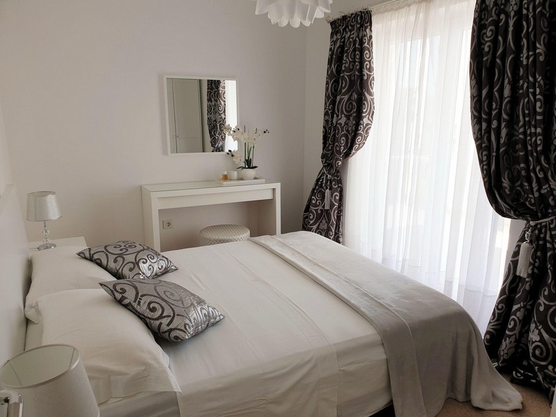 Sypialnia z podwójnym łóżkiem i oknem sięgającym od podłogi do sufitu