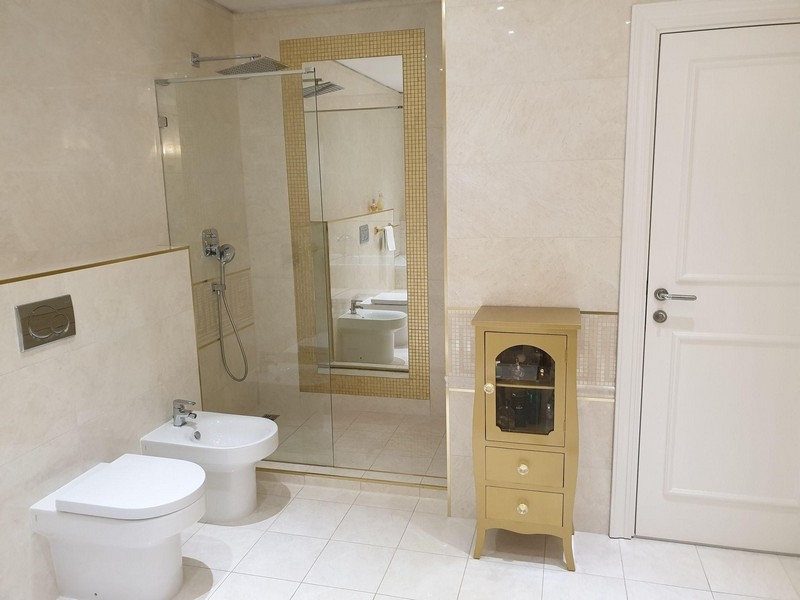 Łazienka z prysznicem, bidetem i jasną podłogą wyłożoną kafelkami