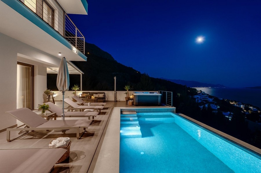 Willa z basenem w nocy i widokiem na morze