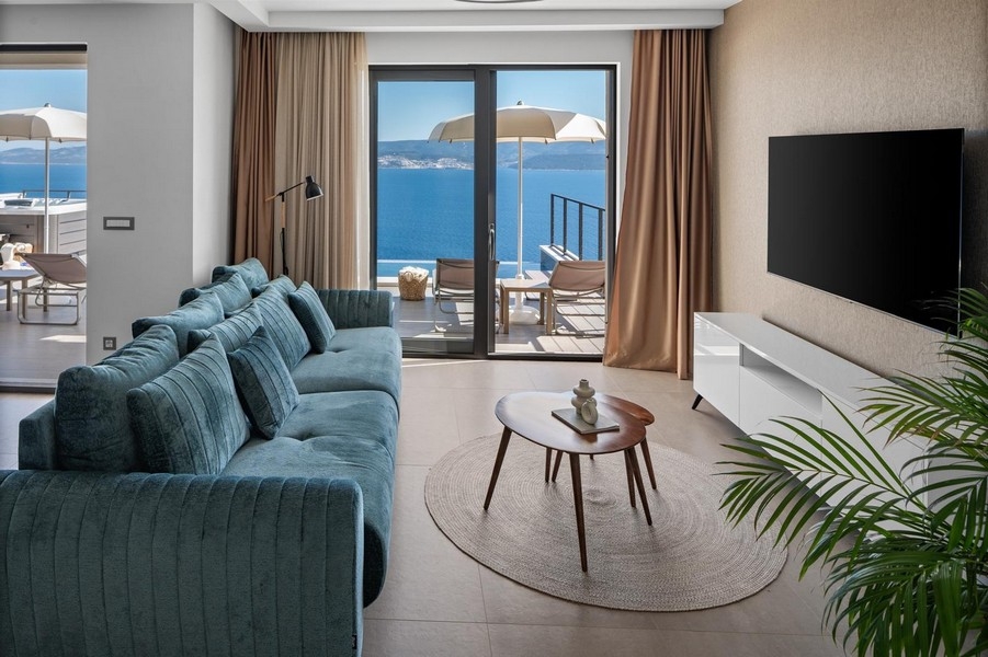 Pokój dzienny z sofą i widokiem na morze przez panoramiczne okna