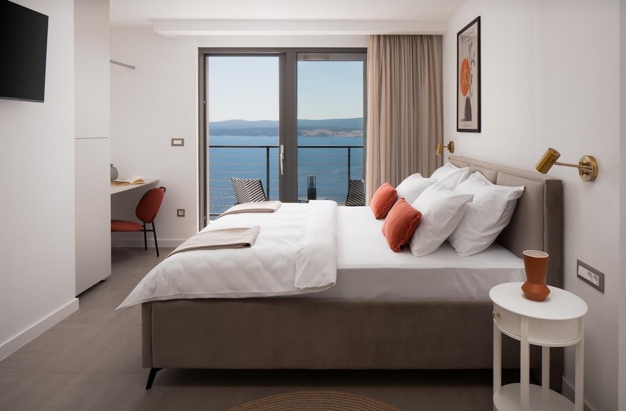 Jasna sypialnia z podwójnym łóżkiem i widokiem na morze