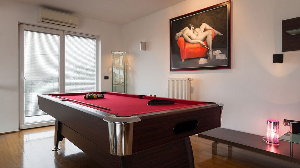 Pokój gier ze stołem bilardowym i nowoczesnymi meblami
