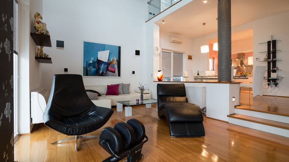 Część dzienna ze skórzanymi fotelami i otwartą kuchnią