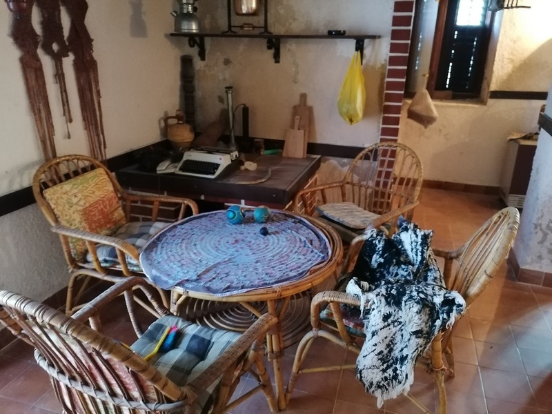 Część wypoczynkowa z meblami rattanowymi i małą kuchnią