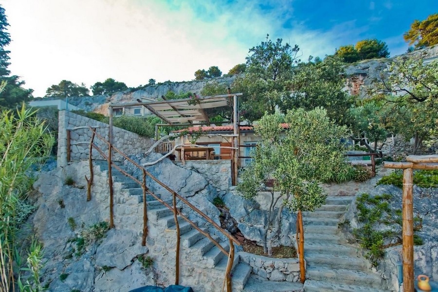 Kamienne schody do domu na zboczu z zadaszonym tarasem