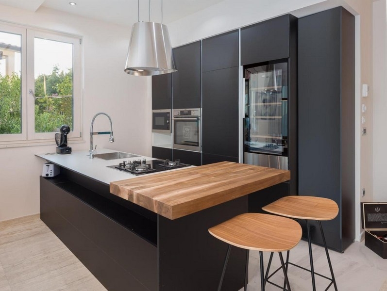 Nowoczesna czarna kuchnia z wyspą i drewnianym blatem
