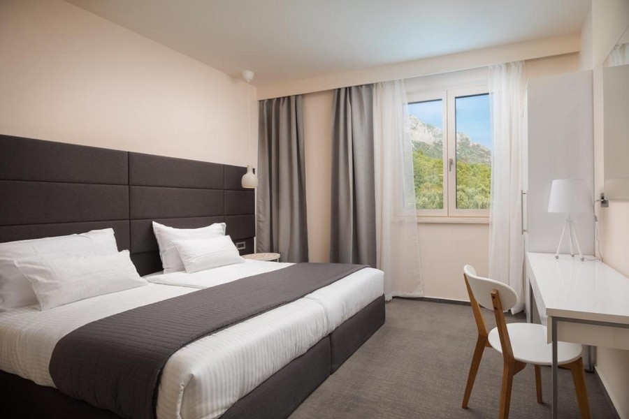 Jasna sypialnia z podwójnym łóżkiem i widokiem na góry