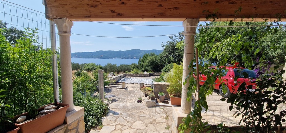 Zadaszony taras z widokiem na zadaszony basen i morze.