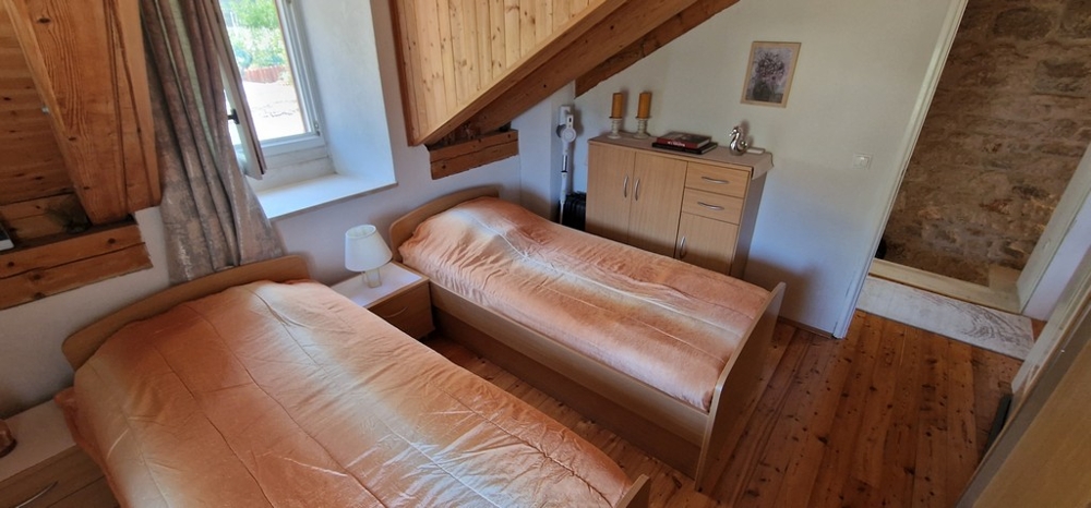 Sypialnia z dwoma pojedynczymi łóżkami i drewnianą podłogą