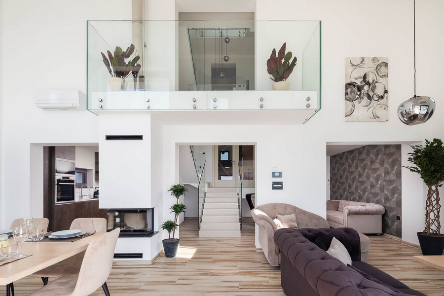 Otwarty salon i jadalnia z galerią i kominkiem