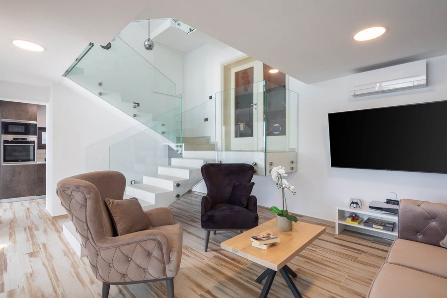 Pokój dzienny ze schodami i szklanymi balustradami