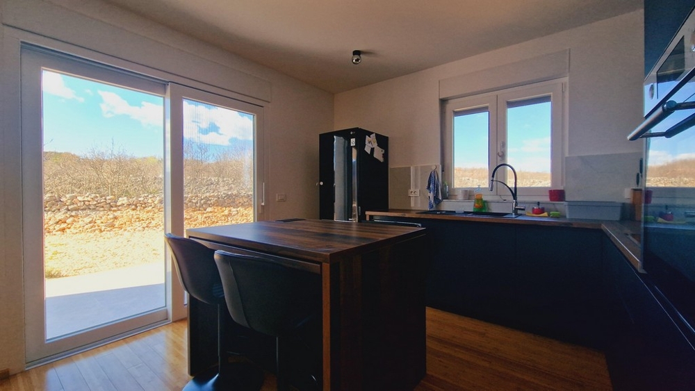 Nowoczesna kuchnia z wyspą kuchenną i wyjściem na ogród