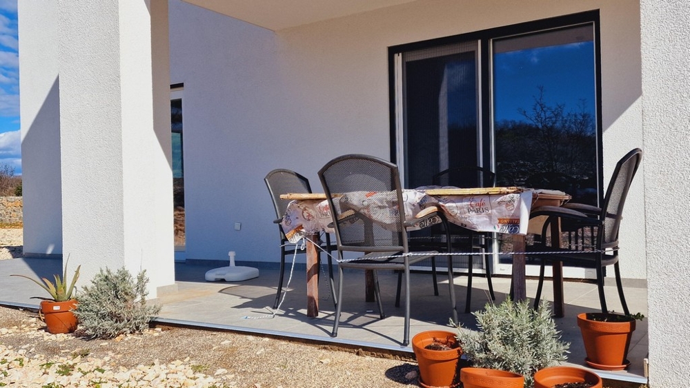 Zadaszony taras ze stołem i krzesłami w ogrodzie