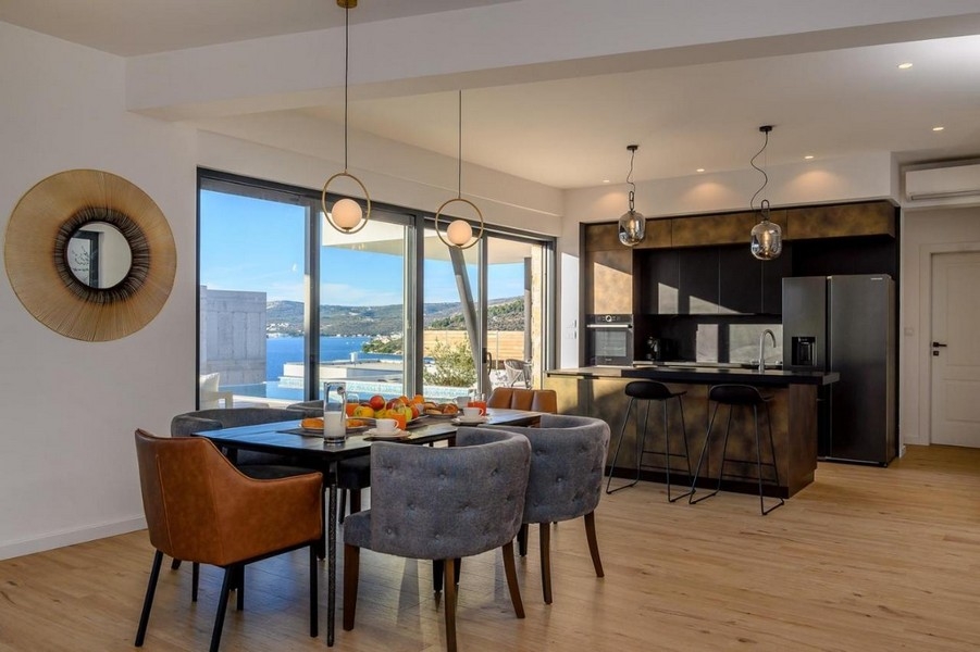 Jadalnia obok kuchni z widokiem na basen i morze