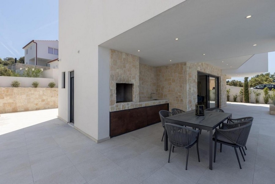 Zadaszony taras z grillem i stołem jadalnym