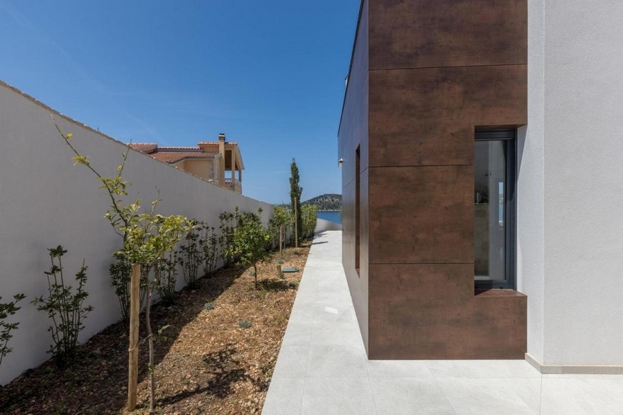 Widok boczny na willę ze ścieżką ogrodową i widokiem na morze