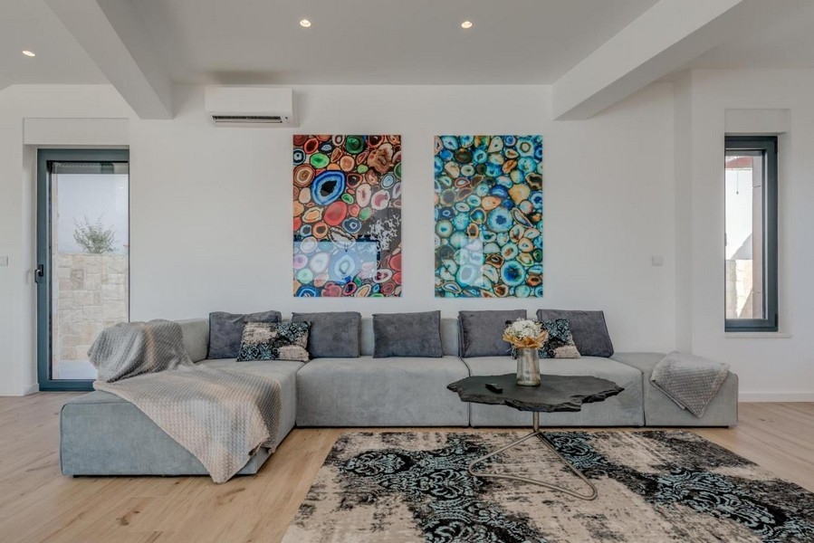 Nowoczesny salon z dużą sofą i malowidłami ściennymi