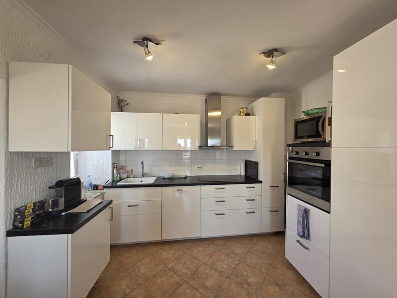 Nowocześnie zabudowana kuchnia z białymi frontami na wysoki połysk