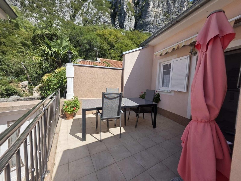 Taras ze stołem, krzesłami i widokiem na skały