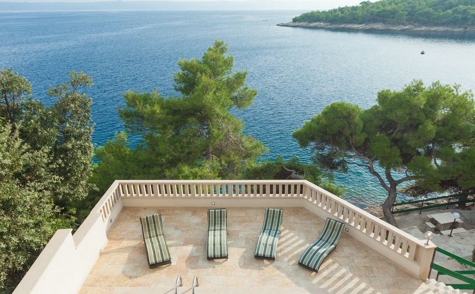 Taras słoneczny z leżakami i panoramicznym widokiem na morze