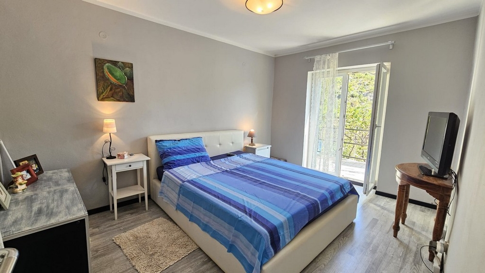 Jasna sypialnia z podwójnym łóżkiem i wyjściem na balkon