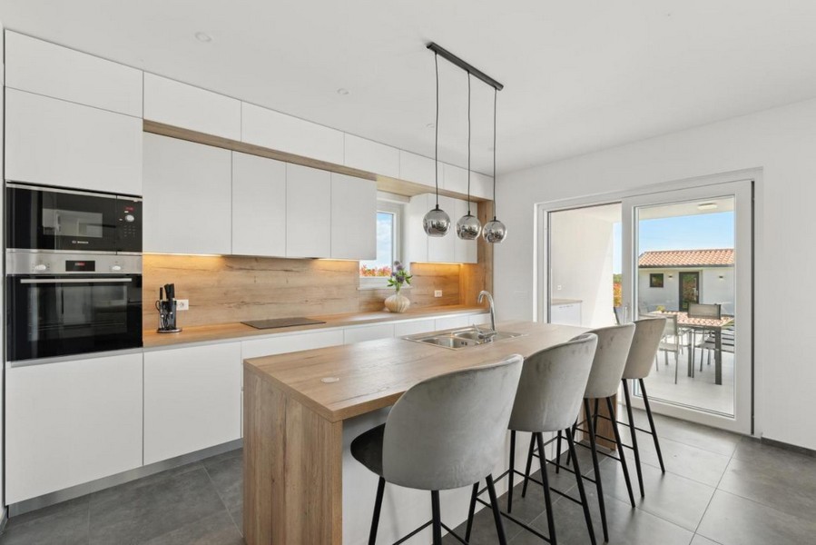 Nowoczesna kuchnia z wyspą i stołkami barowymi
