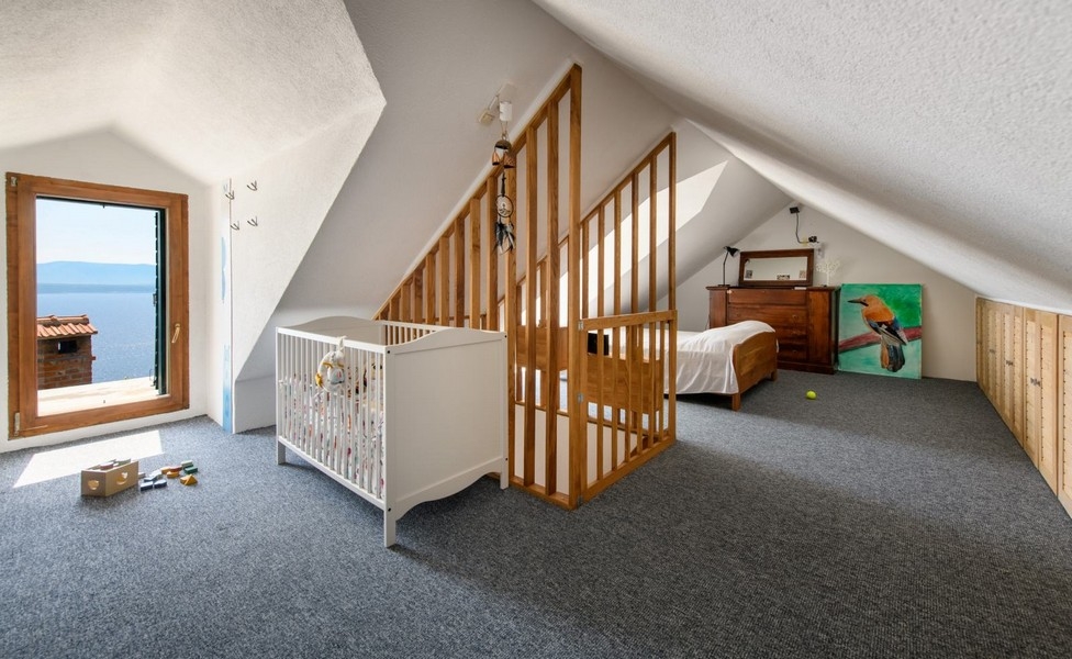 Poddasze z łóżkiem dla dziecka i widokiem na morze