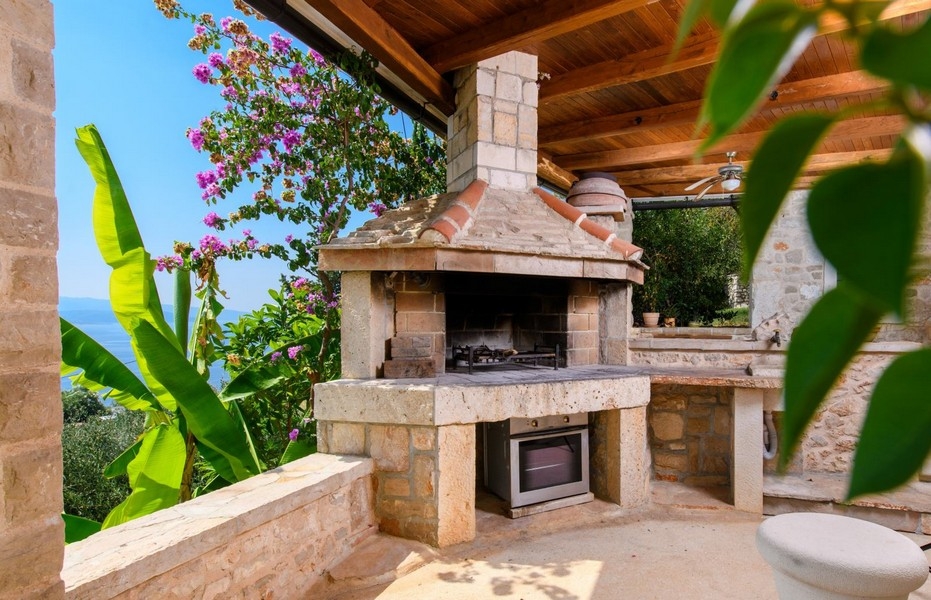 Zadaszona kuchnia letnia z grillem i widokiem na morze