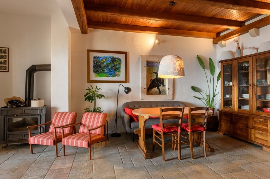 Pokój dzienny z drewnianymi belkami stropowymi, kominkiem i częścią wypoczynkową