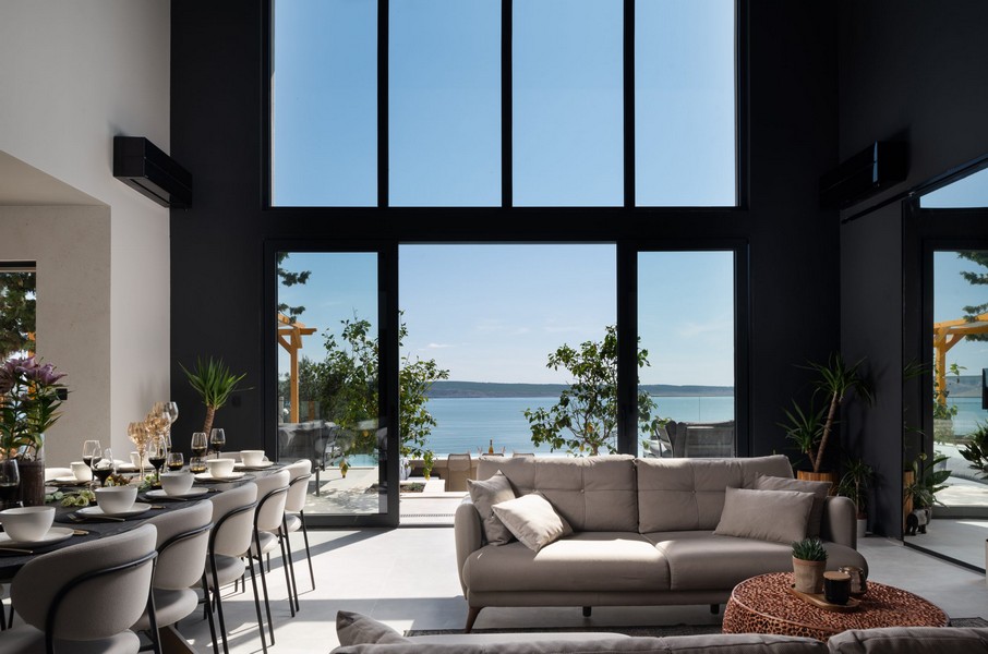 Część dzienna z dużymi panoramicznymi oknami i widokiem na morze