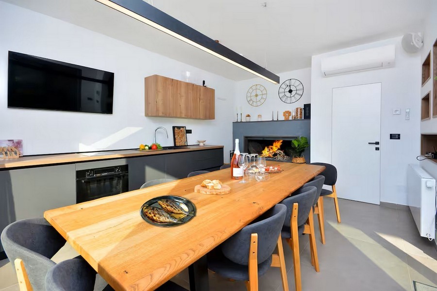 Jadalnia z dużym drewnianym stołem i wewnętrznymi schodami