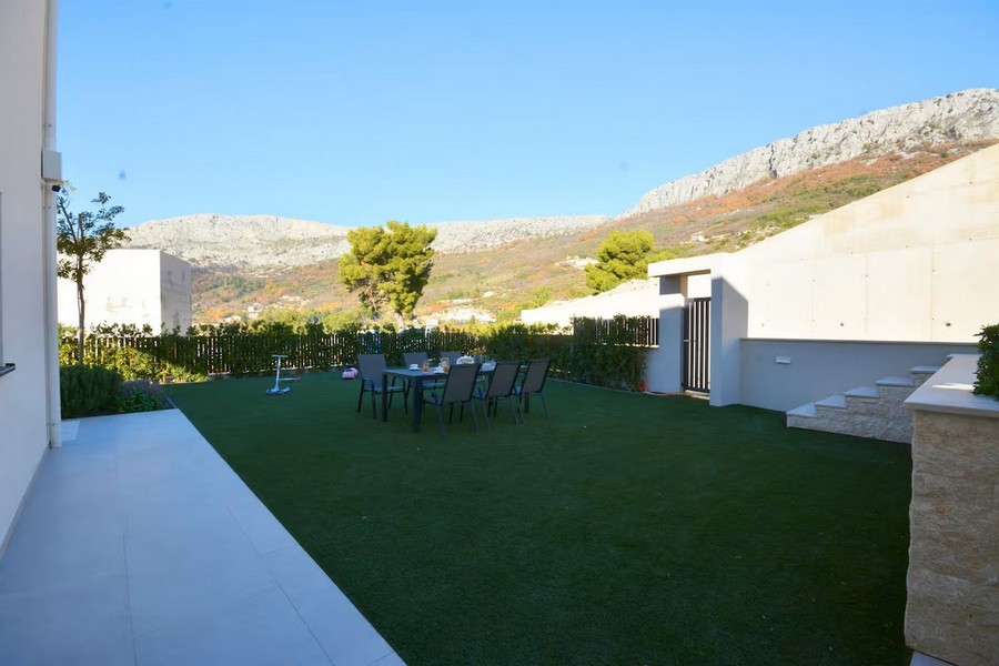 Nowoczesna kuchnia letnia z kominkiem i stołem jadalnym