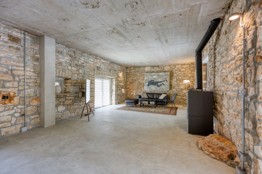 Przestronny salon z kamiennymi ścianami i kominkiem