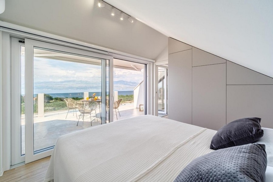 Górna sypialnia z łóżkiem małżeńskim i wyjściem na taras